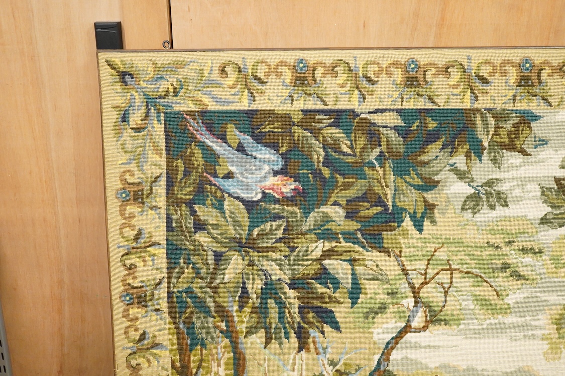 A large framed gross point wool work panel, designed in a verdure foliate palette as a classical French landscape. 161cm wide x 132 cm high.